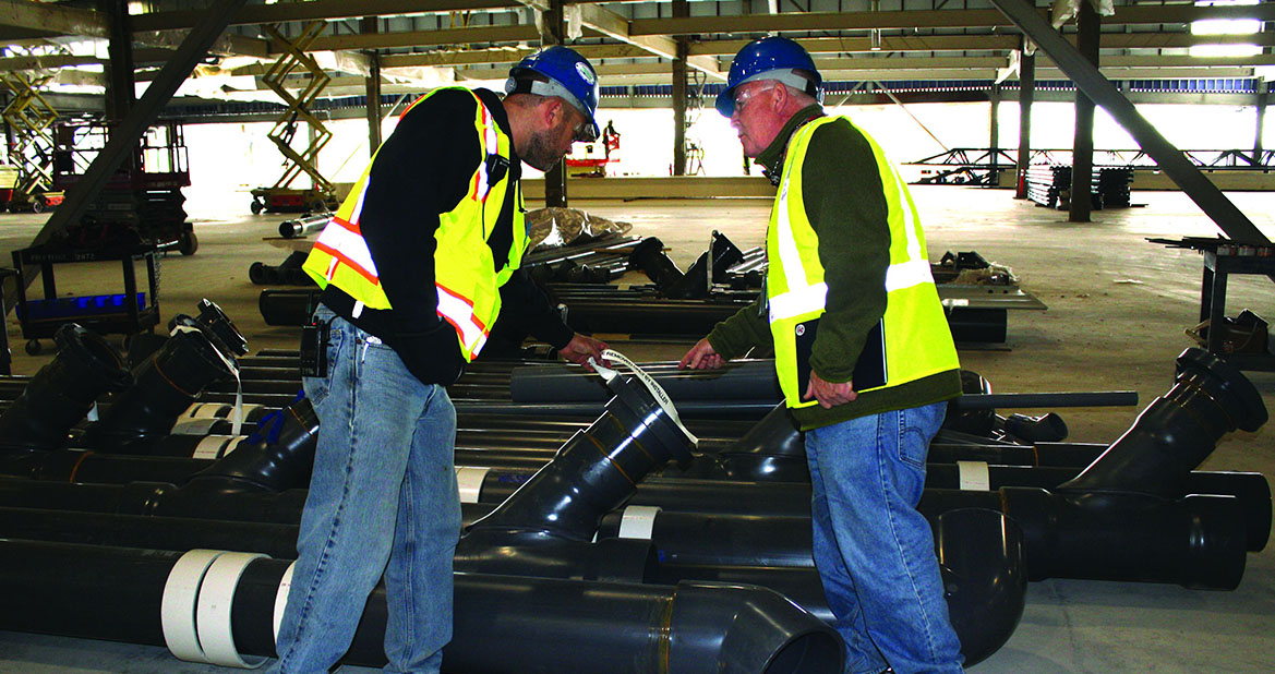 SolarCity’s design/build approach prevented Mollenberg-Betz from ordering all products up front or establishing a regular delivery and installation schedule, so F.W. Webb ordered all of the GF inventory specified in the original job takeoff, stored it nearby, and provides it as needed. Here Mollenberg-Betz Foreman Justin Takas (left) inspects the latest delivery of GF pipe with F.W. Webb Industrial Plastics Manager Jim Matthews.