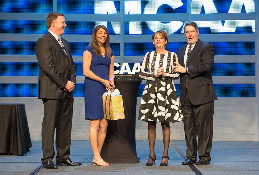 MCAA Immediate Past President Tom Stone looks on as fiancee Sharon Glynn presents a gift to new First Lady Lynne Fuller while MCAA 2017 President Greg L. Fuller looks on.