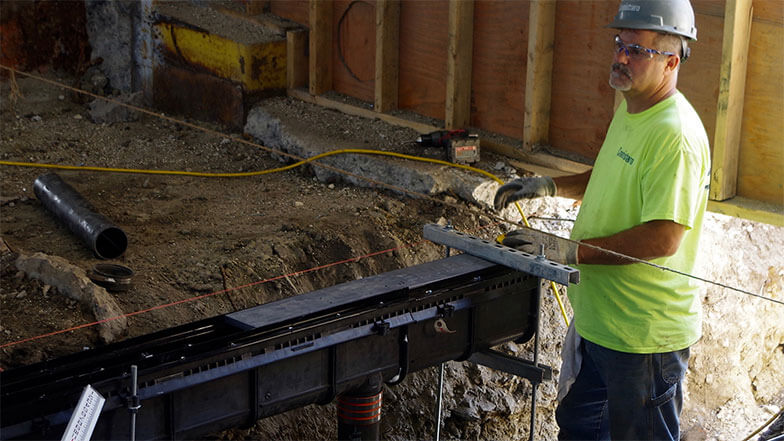 A worker begins installation of a Smith Enviro-Flo® II Trench Drain System